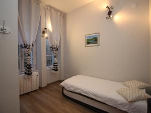 ein Schlafzimmer mit einem Bett und einem Fenster in der Unterkunft Hyper Centre Mont-Dore: T3 spacieux avec balcon et WiFi, à côté des Thermes - FR-1-608-23 in Le Mont-Dore