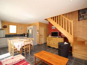 une cuisine et une salle à manger avec une table et un escalier dans l'établissement Chalet spacieux avec terrasse, Wi-Fi et parking - FR-1-608-15, à Le Mont-Dore