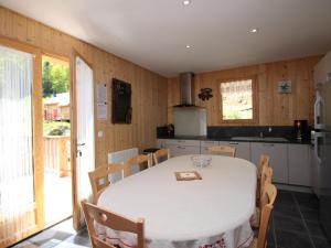 - une cuisine avec une table et des chaises blanches dans la chambre dans l'établissement Chalet spacieux avec terrasse, Wi-Fi et parking - FR-1-608-15, à Le Mont-Dore 8 autres photos