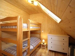 - une chambre avec des lits superposés dans une cabane en rondins dans l'établissement Chalet spacieux avec terrasse, Wi-Fi et parking - FR-1-608-15, à Le Mont-Dore