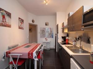 eine kleine Küche mit Tisch und Spüle in der Unterkunft Appartement T3 au Mont-Dore, Centre, 3 étoiles, balcon, ascenseur, WIFI, proche Thermes et navette ski - FR-1-608-17 in Le Mont-Dore