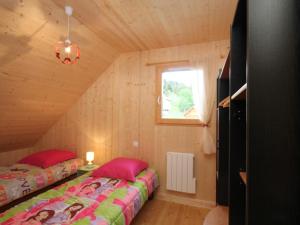 a bedroom with two beds in a wooden cabin at Chalet au Mont-Dore avec terrasse, 2 ch., navette ski, prox. centre & sentiers - FR-1-608-41 in Le Mont-Dore