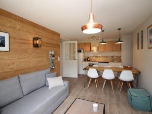 ein Wohnzimmer und eine Küche mit einer Couch und einem Tisch in der Unterkunft Appartement T3 avec Jardin Privatif et WIFI à Mont-Dore, Rénové, Parking et Garage Inclus - FR-1-608-37 in Le Mont-Dore