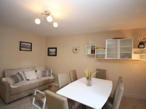 ein Wohnzimmer mit Tisch und Couch in der Unterkunft Le Mont-Dore - Charmant T3 en plein centre-ville avec accès WiFi, proche thermes et commodités - FR-1-608-28 in Le Mont-Dore + 8 Fotos