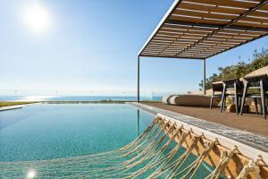 a hammock on the side of a swimming pool at Mani Theasis in Stoupa