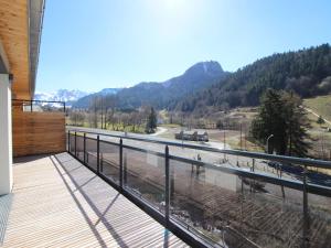 ein Balkon mit Blick auf eine Straße und Berge in der Unterkunft Mont-Dore : Somptueux T2 avec WIFI, terrasse et parking - FR-1-608-45 in Le Mont-Dore