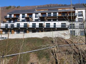 ein Gebäude an der Seite eines Hügels mit einem Gebäude in der Unterkunft Mont-Dore : Somptueux T2 avec WIFI, terrasse et parking - FR-1-608-45 in Le Mont-Dore + 9 Fotos