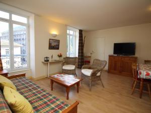 ein Wohnzimmer mit Sofa und Tisch in der Unterkunft La Bourboule T2 bis centre, parking, proche des thermes - FR-1-608-53 in La Bourboule + 6 Fotos