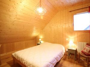 a bedroom with a bed in a wooden room at Chalet spacieux avec terrasse et poêle à bois près du centre - FR-1-608-65 in Le Mont-Dore