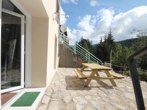 ein hölzerner Picknicktisch auf der Terrasse eines Hauses in der Unterkunft Le Mont-Dore: Beau T2bis avec terrasse, 2 chambres, WiFi - FR-1-608-70 in Le Mont-Dore