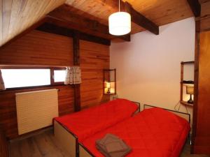 2 camas en una habitación con sábanas rojas en Chalet Mont-Dore, 4 pièces, 9 personnes - FR-1-608-88 en Le Mont-Dore