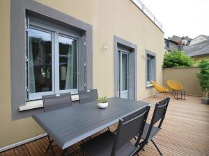 a patio with a table and chairs on a deck at Beau T3 avec terrasse, parking et wifi à 300m des Thermes du Mont-Dore - FR-1-608-79 in Le Mont-Dore