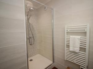 a shower with a glass door in a bathroom at Mont-Dore : T2 spacieux avec terrasse, 300m des thermes, résidence rénovée, parking privé - FR-1-608-98 in Le Mont-Dore