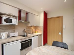 eine Küche mit Spüle und Mikrowelle in der Unterkunft T2 de Standing à 300m des Thermes du Mont-Dore avec Parking et Ascenseur - FR-1-608-99 in Le Mont-Dore + 4 Fotos