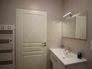 Un baño blanco con lavabo y espejo. en Bel Appartement T3 avec WIFI et Parking, Résidence de Standing, 300m des Thermes au Mont-Dore - FR-1-608-87, en Le Mont-Dore 7 fotos más
