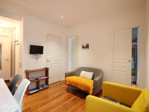 ein Wohnzimmer mit einer Couch und einem Sessel in der Unterkunft Charmant appartement T3 avec Wifi au centre de La Bourboule, proche Thermes et commerces - FR-1-608-96 in La Bourboule