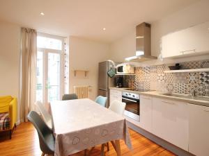 a kitchen with a white table and chairs and a table and a kitchen with at Appartement La Bourboule, 3 pièces, 5 personnes - FR-1-608-96 in La Bourboule