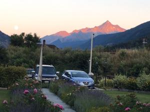 two cars parked in a parking lot with mountains in the background at Appartamento Montagnards in Morgex
