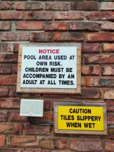 a sign is posted on a brick wall at Blue Tides in Port Elizabeth