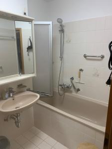 ein Badezimmer mit einem Waschbecken, einer Badewanne und einer Dusche in der Unterkunft Fewo Christine in Prien am Chiemsee