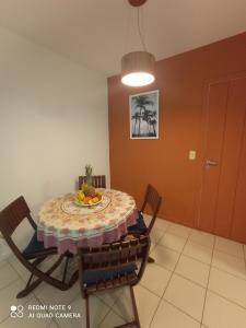 a dining room table with a plate of fruit on it at Village Hospedagens in Natal