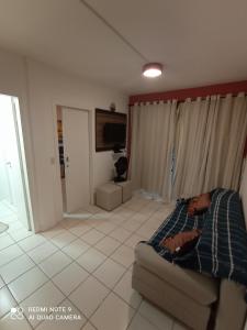 a bedroom with a bed and a tv in it at Village Hospedagens in Natal