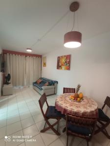 a living room with a table and chairs and a couch at Village Hospedagens in Natal