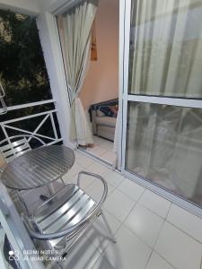 una silla en un balcón con mesa y ventana en Village Hospedagens, en Natal