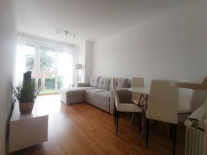 - un salon blanc avec un canapé et une table dans l'établissement Apartamento céntrico con piscina y garaje, à Suances