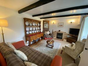a living room with a couch and a fireplace at Scenic Welsh Cottage in the Brecon Beacons in Crickhowell
