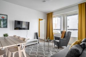 a living room with a table and a dining room at Hiisi Homes Turku Ratapiha in Turku