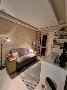 sala de estar con sofá y mesa en Flat com lareira em Campos do Jordão, en Campos do Jordão