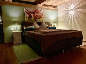 a bedroom with a bed with a picture of a cow on the wall at Ferienwohnung mit Luxusbad, Terrasse Ostseenähe in Gremersdorf