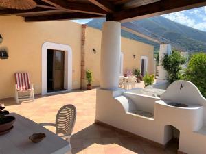 a patio with a tub and a table and chairs at Casa Il Girasole, panoramica e a pochi passi dal centro di Malfa in Malfa +19 photos