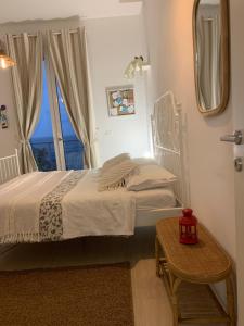 a bedroom with a bed with a window and a table at Sea view life in Carini