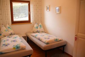 a room with two beds in it with a window w obiekcie Ferienwohnung Lavendel w mieście Ellmau