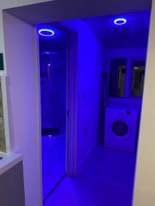 a blue room with a bathroom with a washing machine at Calm residential house in Wyken