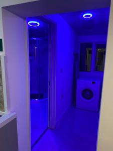 a blue room with a bathroom with a washing machine at Calm residential house in Wyken