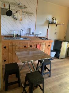 een keuken met een houten tafel en 2 krukken bij cabaña del bosque in Villarrica