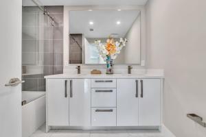 a white bathroom with two sinks and a mirror at VillaPlaya brand new home, modern style resort! in Fort Lauderdale +19 photos
