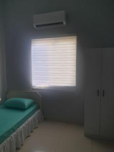 a bedroom with a window with a green bed in it at Sarod Inn Meru Homestay 3-bedroom Apartment in Klang