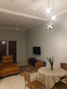 a living room with a table and a couch at Sarod Inn Meru Homestay 3-bedroom Apartment in Klang