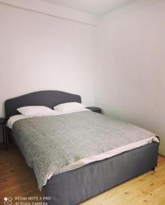 a bed in a room with a white wall at Bellevue in Zlatibor