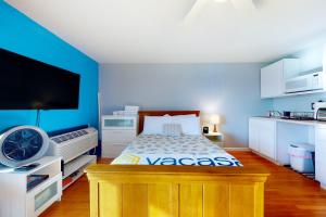 a bedroom with a bed and a tv in a room at Little Gem at Hampton Beach in Hampton