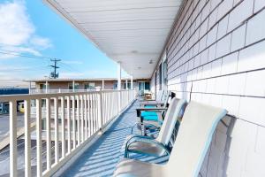 une rangée de chaises et de tables sur un balcon dans l'établissement Little Gem at Hampton Beach, à Hampton Beach