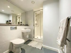a white bathroom with a toilet and a shower at Liverpool City Centre Studio Apartment in Liverpool