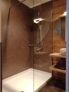 a shower with a glass door in a bathroom at Auberge de la Motte in Les Combes