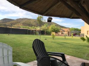 two chairs sitting on a patio with a field of grass at BRISAS DEL VALLE San Rafael in Valle Grande