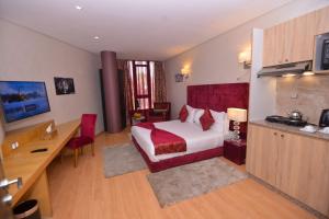 Le 135 appart hotel في الدار البيضاء: غرفه فندقيه بسرير ومكتب ومطبخ