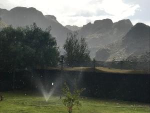 a garden with a fence and mountains in the background at BRISAS DEL VALLE San Rafael in Valle Grande